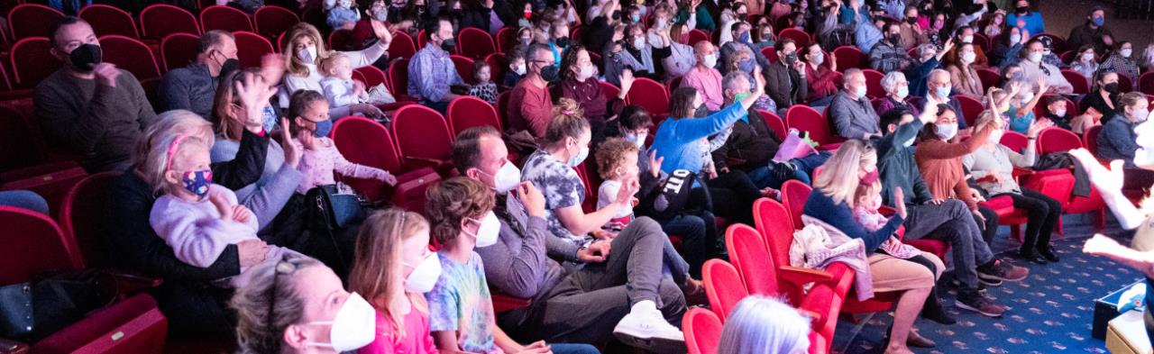 Audience patrons of all ages wearing masks.