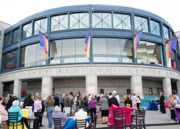 Exterior of the Lesher Center during a happy hour event with people outside on the plaza