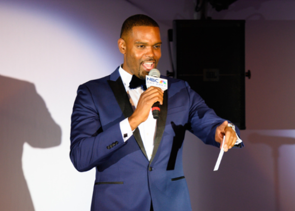 NBC Bay Area News Anchor Marcus Washington speaks into mic while pointing