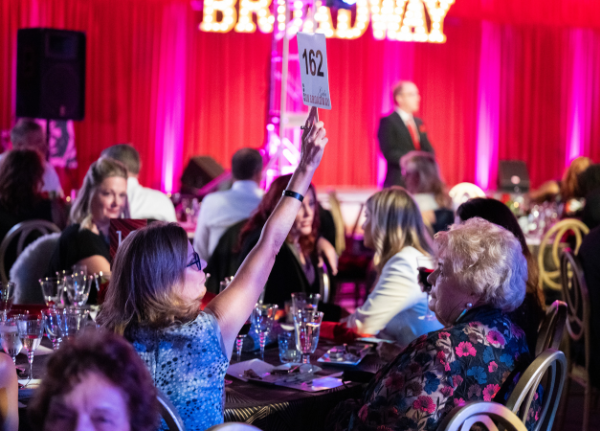 Someone raising a bid paddle at On Broadway Gala